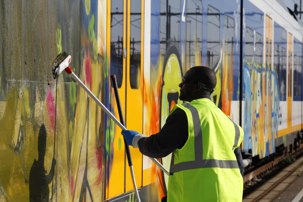 Een professional verwijdert graffiti van een trein